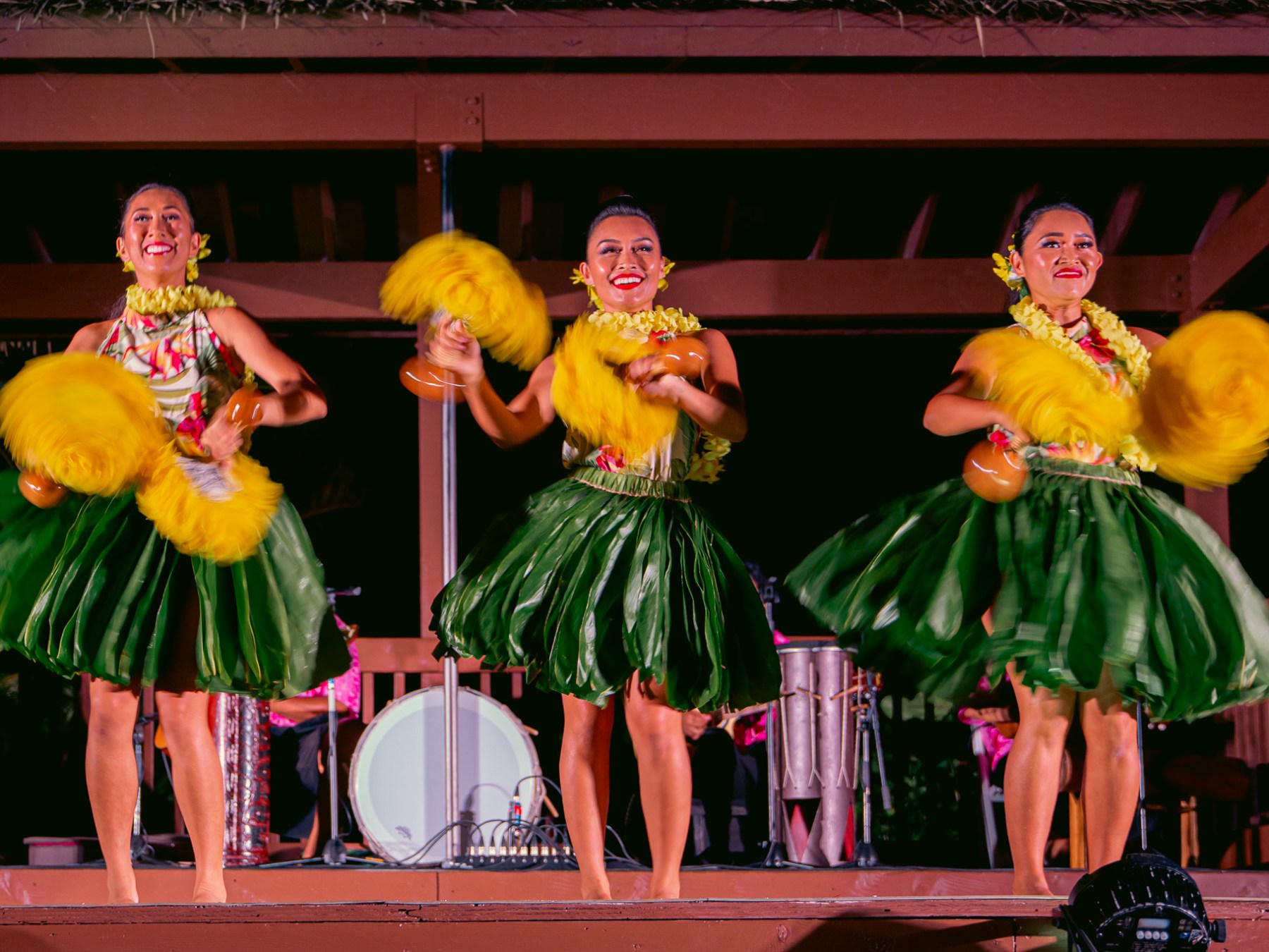 a group of people sitting at a table with a vase of flowers