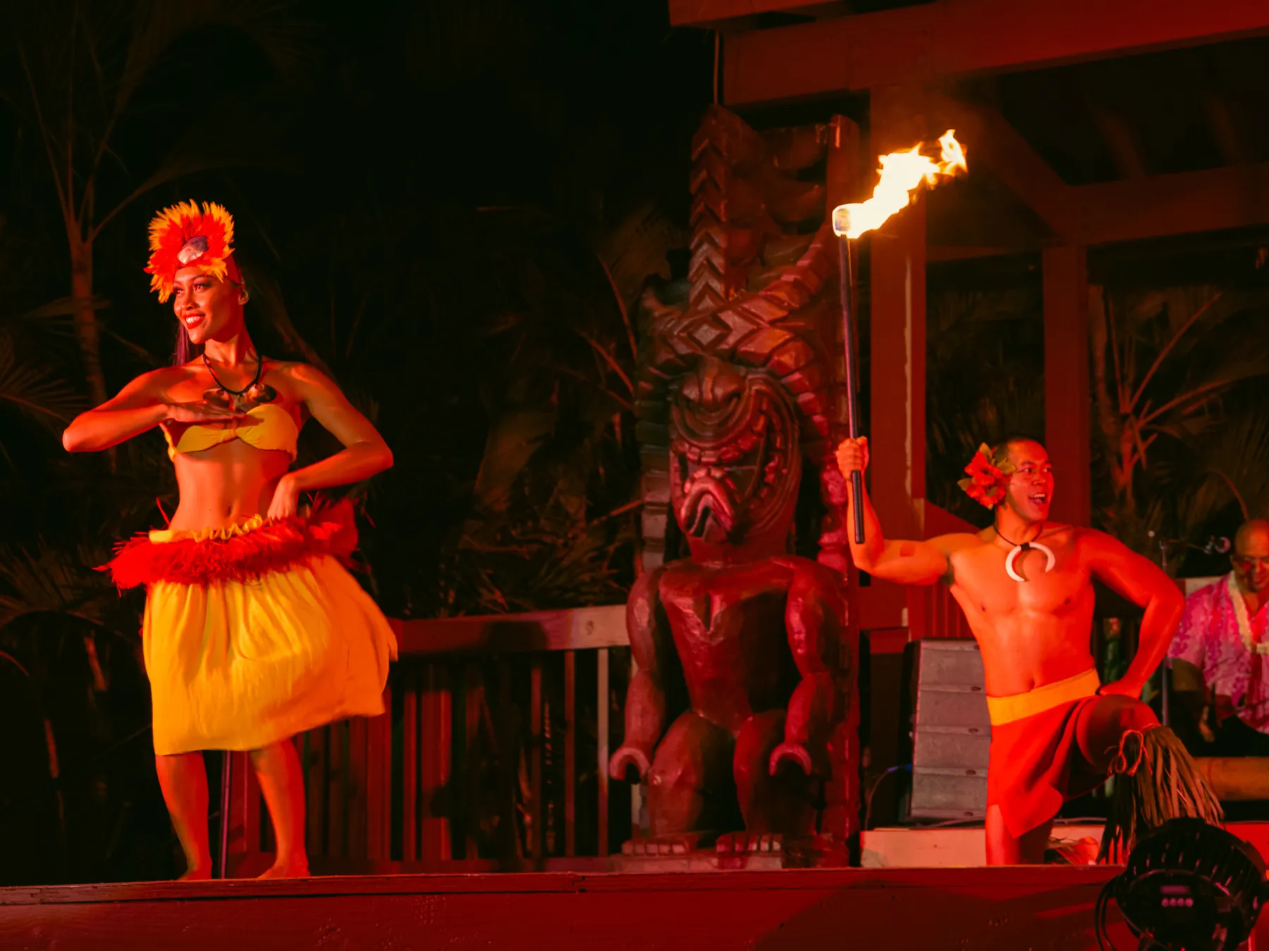 a group of people in a dark room with a christmas tree