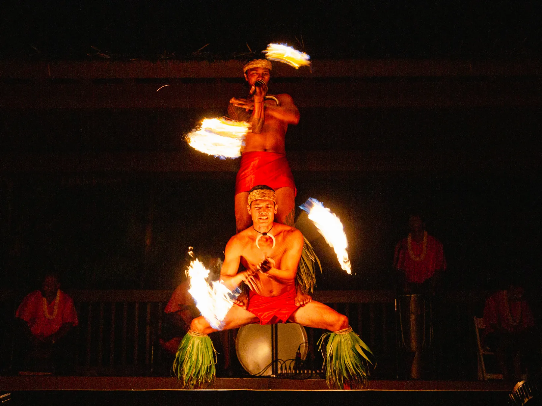a man sitting at a fire in the dark